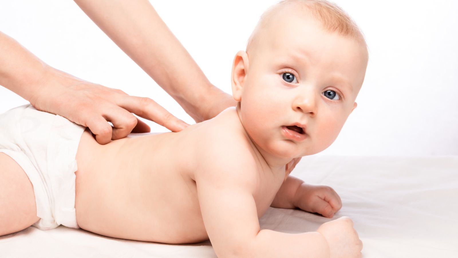 Bebé boca abajo recibiendo tratamiento de osteopatía infantil