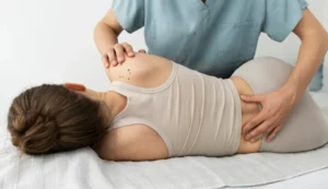 Fisioterapeuta tratando el hombro y la espalda de una paciente en camilla