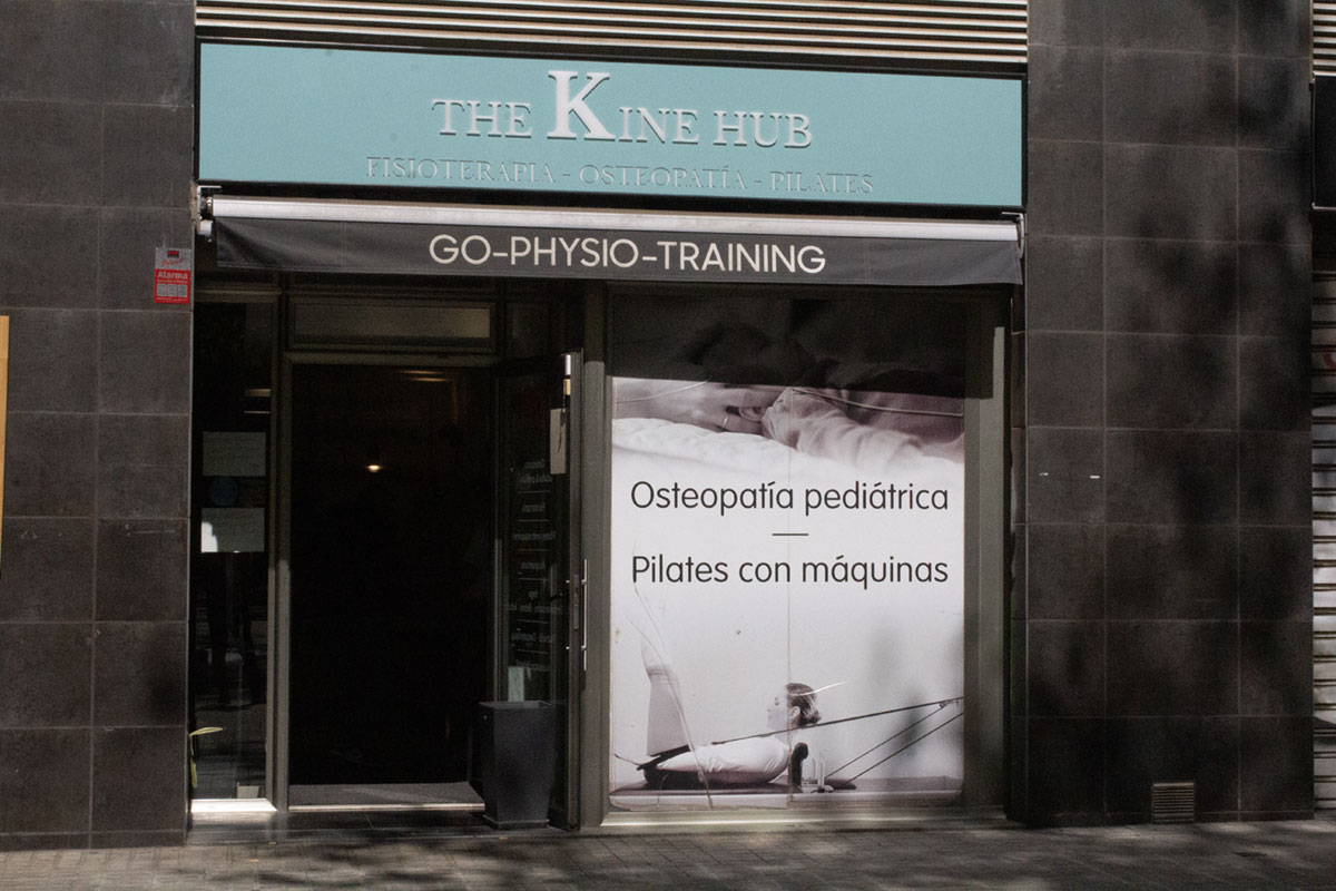 Fachada de la clínica The Kine Hub con rótulo de osteopatía pediátrica y pilates con máquinas